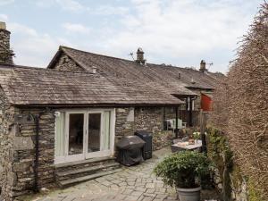 an external view of a stone cottage with a patio at Hart Head Barn in Ambleside