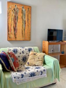 a living room with a couch and a painting on the wall at Villas da Jagua in Jaguaruna