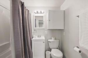 uma casa de banho com um WC, um lavatório e um espelho. em 2-Bedroom Bungaloo nestled close to Urban Centers em Vancouver