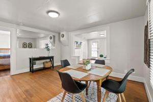 een eetkamer met een tafel en stoelen en een piano bij 2-Bedroom Bungaloo nestled close to Urban Centers in Vancouver