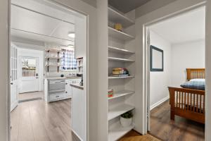 une cuisine avec des étagères blanches dans une pièce dans l'établissement 2-Bedroom Bungaloo nestled close to Urban Centers, à Vancouver