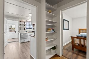 a kitchen with white shelves in a room at 2-Bedroom Bungaloo nestled close to Urban Centers in Vancouver