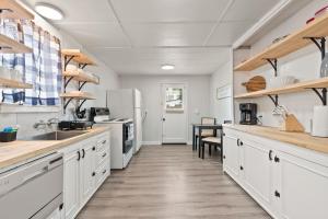a large kitchen with white cabinets and a table at 2-Bedroom Bungaloo nestled close to Urban Centers in Vancouver +18 photos