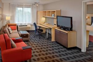 a living room with a desk and a television in a room at TownePlace Suites by Marriott Albany Downtown/Medical Center in Albany