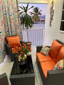 a living room with a couch and a table with flowers at Pearls Place in Arima