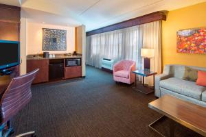 Habitación de hotel con sofá y silla en Courtyard Marriott Lake Placid, en Lake Placid