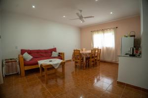 ein Wohnzimmer mit einem roten Sofa und einem Tisch in der Unterkunft Las Moras Del Manantial in Termas de Río Hondo