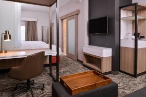 a hotel room with a desk and a bed at SpringHill Suites by Marriott Greensboro Airport in Friendship