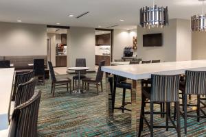a dining room with chairs and tables and a bar at Residence Inn by Marriott Dallas Plano/Richardson at Coit Rd. in Plano