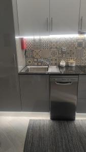 uma cozinha com um lavatório de aço inoxidável e uma máquina de lavar louça em Light Wave Nazare Center 50m Beach na Nazaré mais 20 fotografias