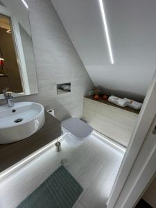 uma casa de banho branca com um lavatório e um WC em Light Wave Nazare Center 50m Beach na Nazaré
