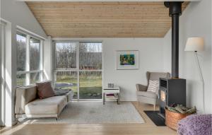 een woonkamer met een bank, stoelen en ramen bij Beautiful Home In Skibby With Wifi And 4 Bedrooms in Skibby
