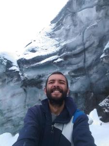 a man is standing in front of a glacier at Great location bed and breakfast in Latacunga