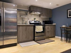 een keuken met een koelkast en een fornuis top oven bij Walkout 1 Bed, 1 Bath Bsmnt Apt in Ajax