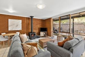 a living room with two couches and a fireplace at Split Point Cottages in Aireys Inlet