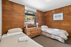 a bedroom with two beds and a window at Split Point Cottages in Aireys Inlet