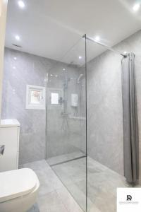 a bathroom with a shower and a toilet at WEEKLY & MONTHLY STAY - Beautiful 2 Bed House with FREE Parking - Relocation, Business & Group - 5 Guests - By Den Accommodation Short Lets & Serviced Accommodation, Woolwich in Woolwich