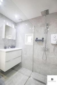 a bathroom with a shower and a sink at WEEKLY & MONTHLY STAY - Beautiful 2 Bed House with FREE Parking - Relocation, Business & Group - 5 Guests - By Den Accommodation Short Lets & Serviced Accommodation, Woolwich in Woolwich