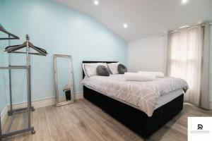 Woolwich的住宿－WEEKLY & MONTHLY STAY - Beautiful 2 Bed House with FREE Parking - Relocation, Business & Group - 5 Guests - By Den Accommodation Short Lets & Serviced Accommodation, Woolwich，一间卧室配有一张大床和镜子