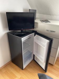 einen kleinen Kühlschrank mit einem TV darüber. in der Unterkunft Ferienwohnung Fürth in Fürth