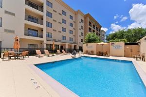 a swimming pool in front of a building with a hotel at Courtyard Laredo in Laredo