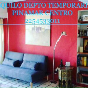 sala de estar con sofá azul y pared roja en Martin Pescador en Pinamar