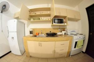 a kitchen with a white refrigerator and a sink at Alojamiento en Playa Herradura in Herradura