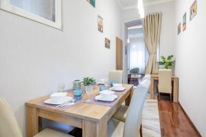 ブダペストにあるBasilica View Apartmentのダイニングルーム(木製テーブル、白い椅子付)