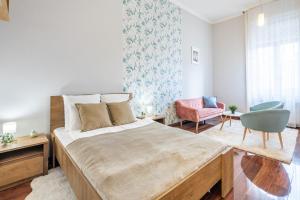 Un dormitorio con una cama grande y una silla. en Basilica View Apartment, en Budapest