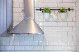 una cocina con capucha de acero inoxidable y macetas en Basilica View Apartment, en Budapest