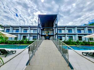 uma passagem que leva a um grande edifício com piscina em Hotel Capri Doradal em Doradal