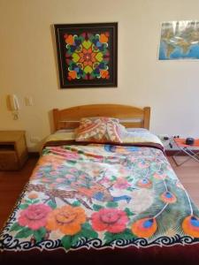 ein Bett mit einer bunten Decke in einem Schlafzimmer in der Unterkunft Paraíso del Salitre II in Bogotá