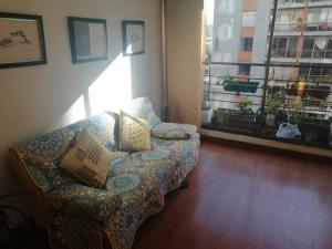 ein Wohnzimmer mit einem Sofa und einem Fenster in der Unterkunft Paraíso del Salitre II in Bogotá
