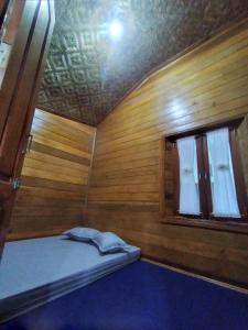 een kleine kamer met een bed en een raam bij RGA Homestay in Baso