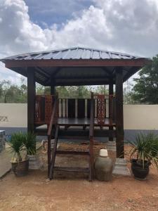 un gazebo con due sedie sotto un tetto di Nazirah Homestay a Pasir Mas