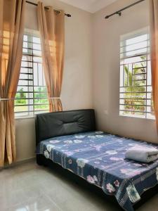 una camera con un letto e due finestre di Nazirah Homestay a Pasir Mas
