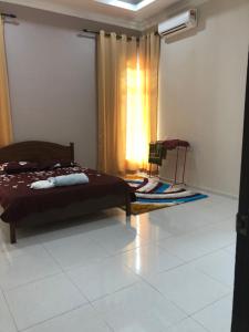 una camera con un letto e una finestra con un tappeto di Nazirah Homestay a Pasir Mas