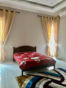 una camera con letto rosso in una stanza con finestra di Nazirah Homestay a Pasir Mas