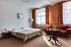 um quarto com uma cama, uma cadeira e uma mesa em Janne Hotel em Riga