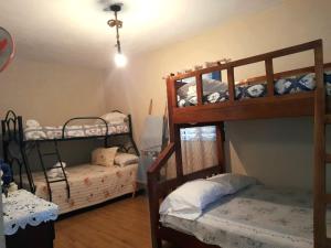 a room with two bunk beds and a bed at Cabaña Don Tobo Jarabacoa RD in Jarabacoa