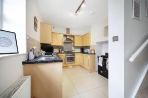 a kitchen with wooden cabinets and a sink at Lovely little house, free on street parking, Smart TV, WiFi in Gloucester