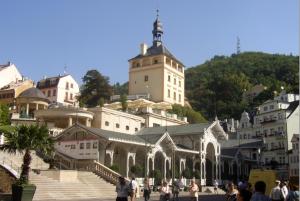 a group of people walking around a building with a tower at Pension Villa Maria in Karlovy Vary