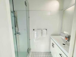 a white bathroom with a shower and a sink at The Lucinda White House in Lucinda +22 photos