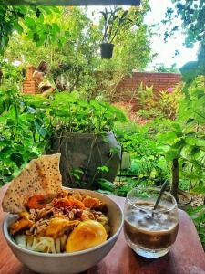 un tazón de comida sentado en una mesa con una bebida en Angel Garden Villa en Hoi An