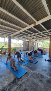- un groupe de personnes faisant du yoga dans une chambre dans l'établissement Tipsea Turtle Rooftop Hostel Gili Trawangan, à Gili Trawangan