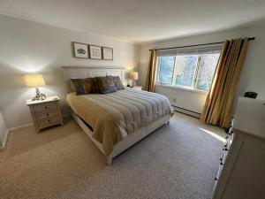 Un dormitorio con una cama grande y una ventana en F7 Comfortable golf course townhouse within walking distance of Mount Washington Hotel, en Carroll