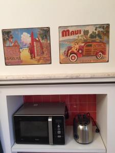 a microwave in a kitchen with two pictures above it at B&B la casa di Pina in Bergamo