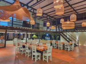 a dining room with a long table and white chairs at Hotel Capri Doradal in Doradal