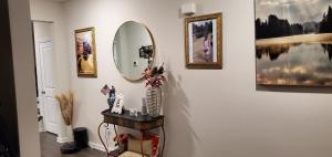 528 Carroll Walk Avenue في فريدريك: غرفة مع مرآة وطاولة مع مزهرية