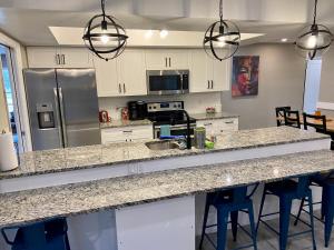 a kitchen with granite counter tops and stainless steel appliances at Spacious 5 bedrooms 3 bathrooms Family-Friendly Home With Heated salt Pool in Clearwater